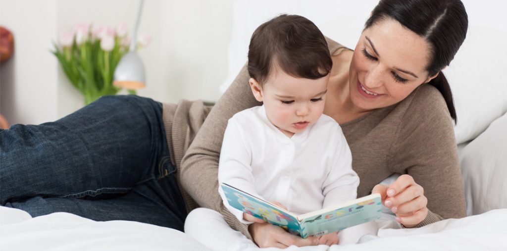 bebeğine kitap okuyan anne