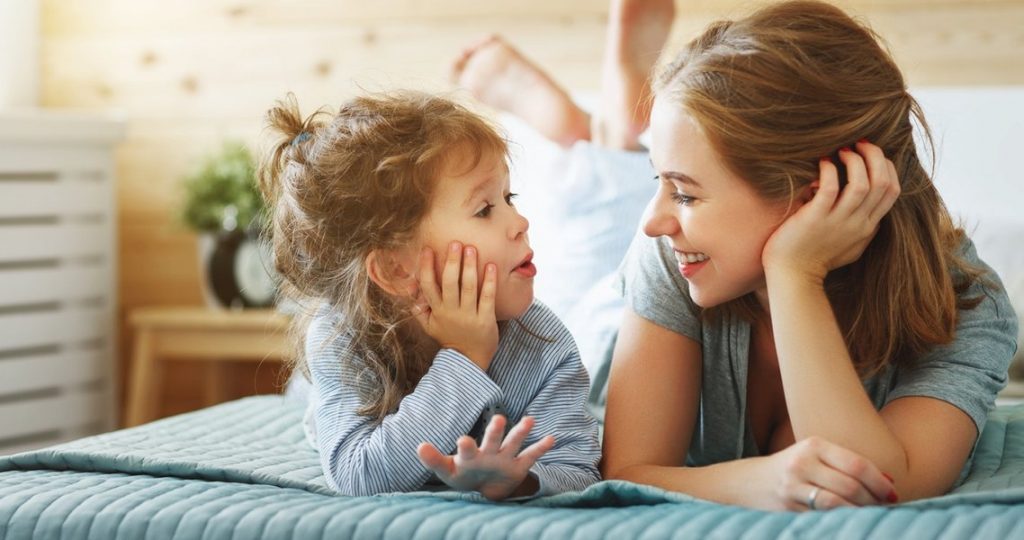Küçük kız çocuğu heyecanlı bir şekilde annesiyle sohbet ediyor