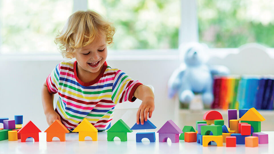 Lego oyuncaklardan çok sayıda ev yapan bir çocuk