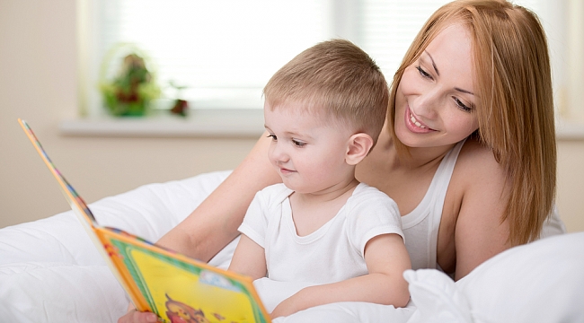 Bebeğine kitap okuyan bir anne 
