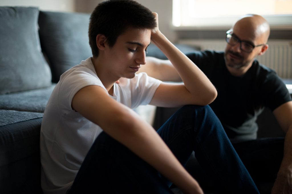üzgün genç bir çocuk babasıyla sohbet ediyor